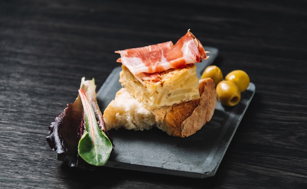 Primo piano di un piatto con alcuni tipici pincho de tortilla spagnoli e pincho de jamon