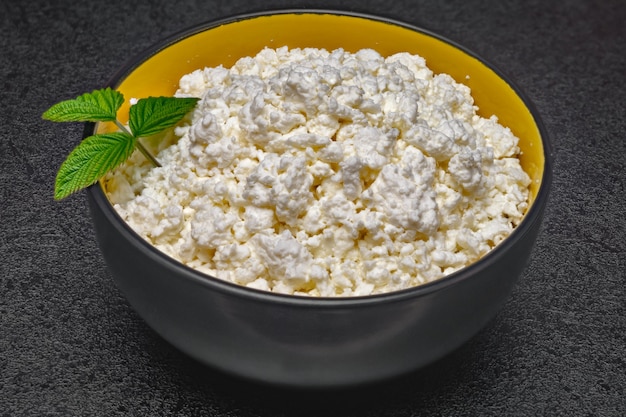 Primo piano di un piatto con ricotta decorata con erbe sul tavolo.