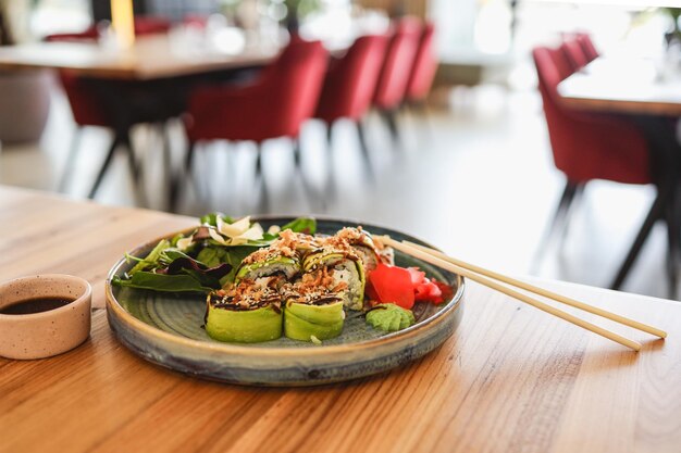 Primo piano di un piatto di sushi su un tavolo del ristorante con un interno sfocato sullo sfondo