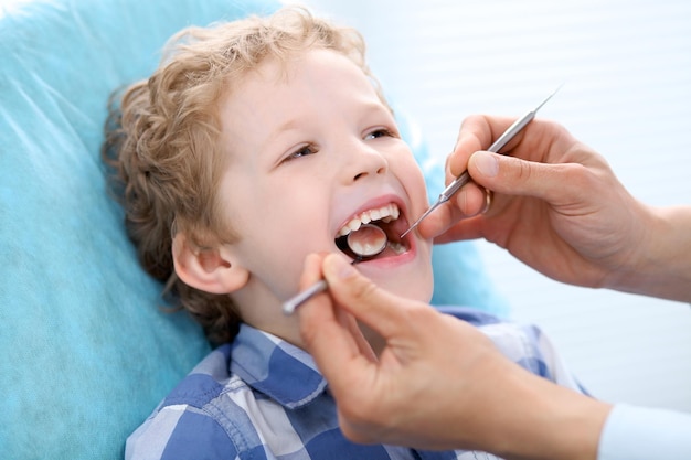 Primo piano di un ragazzo che si fa esaminare i denti da un dentista.