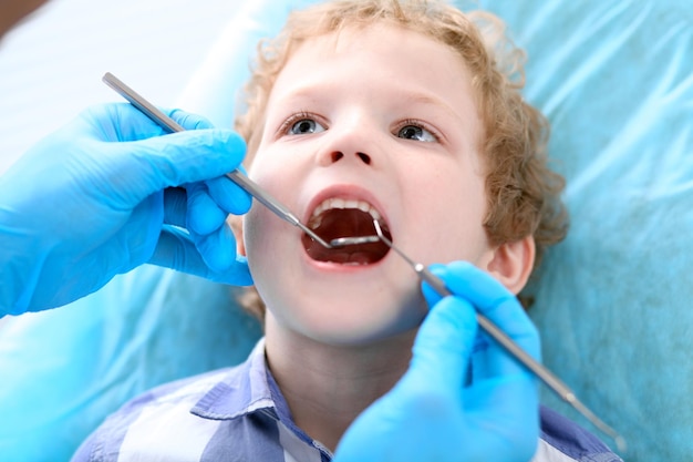 Primo piano di un ragazzo che si fa esaminare i denti da un dentista