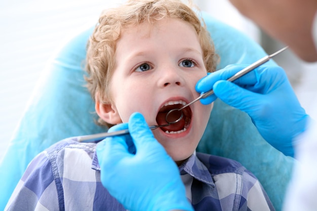 Primo piano di un ragazzo che si fa esaminare i denti da un dentista.