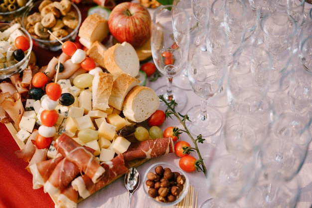 Primo piano di un tagliere di legno con salumi e formaggio e pane su un tavolo di specialità gastronomiche