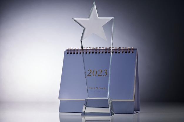 Primo piano di un trofeo di vetro e un calendario da tavolo 2023