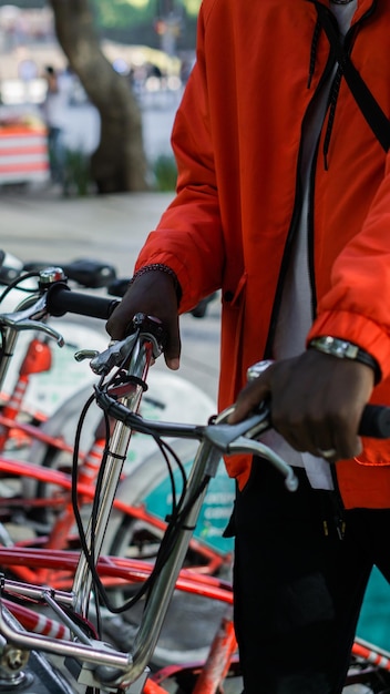 Primo piano di un uomo africano che guida una bicicletta in un parco esterno.