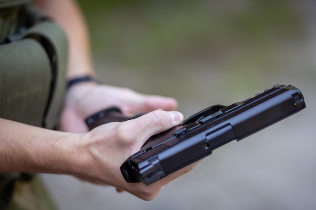 Primo piano di un uomo che ricarica una pistola softair