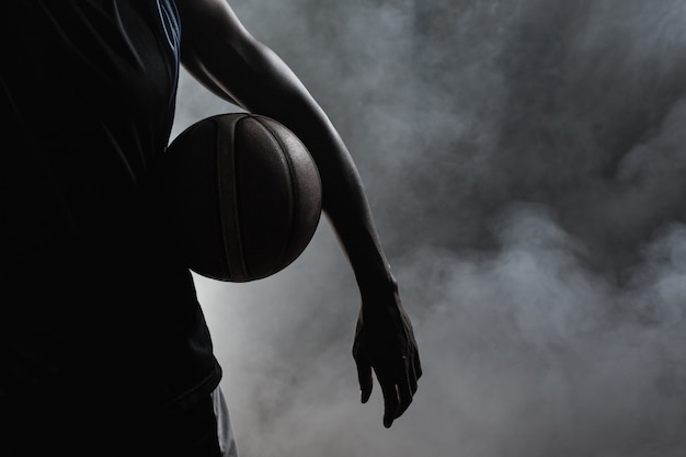 Primo piano di un uomo che tiene un pallone da basket