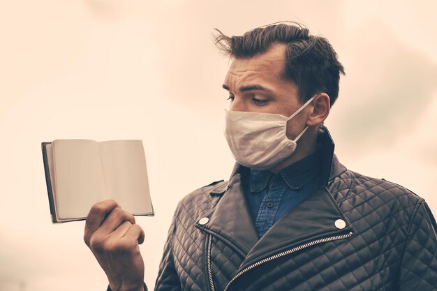 Primo piano di un uomo con una maschera protettiva che presenta la sua foto del passaporto con un copyspace