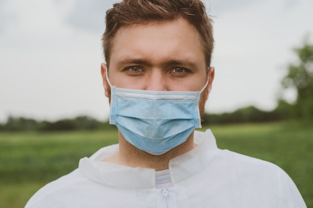 primo piano di un uomo in una tuta protettiva e outodoor maschera medica