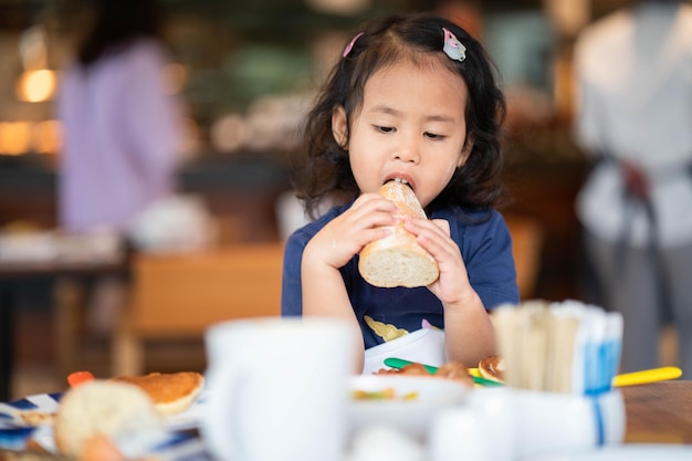 Primo piano di una bambina che mangia una pagnotta