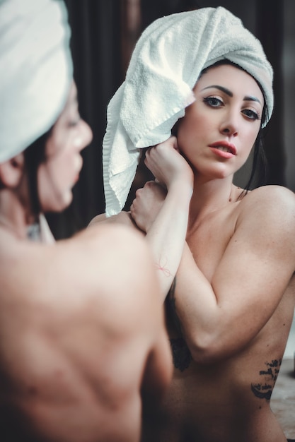 Primo piano di una bella donna dopo la doccia, con un asciugamano sulla testa