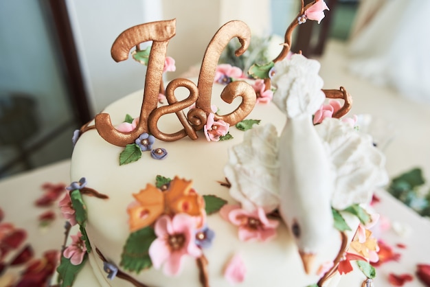 Primo piano di una bella torta nuziale con fiori decorativi.