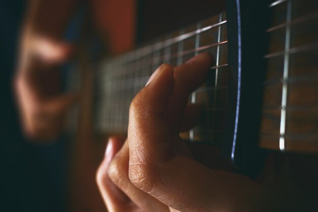 Primo piano di una chitarra acustica in riproduzione.