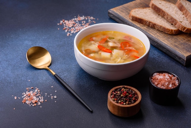 Primo piano di una ciotola di noodle di pollo e zuppa di verdure su un tavolo di cemento