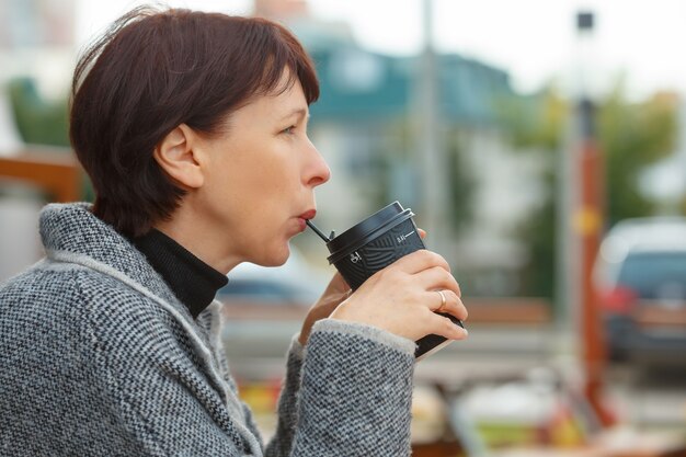 Primo piano di una donna che beve caffè o cioccolato caldo