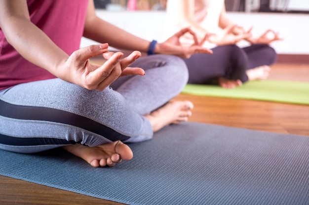 Primo piano di una donna che fa yoga in una posizione di meditazione all'interno della palestra. Concetto di praticare la calma o la pace e il relax. Esercizio per la buona salute del corpo e la salute mentale.