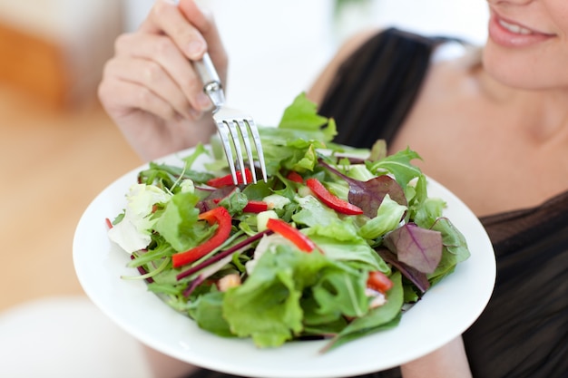 Primo piano di una donna che mangia un&#39;insalata