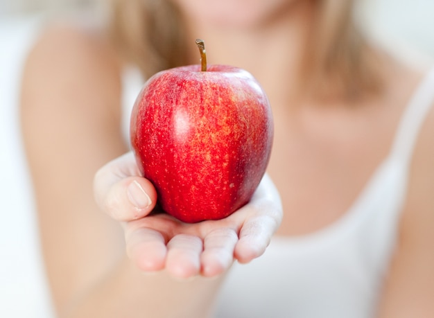 Primo piano di una donna che mostra una mela