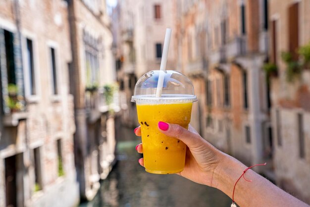 Primo piano di una donna che tiene in mano un bicchiere di succo di ananas fresco