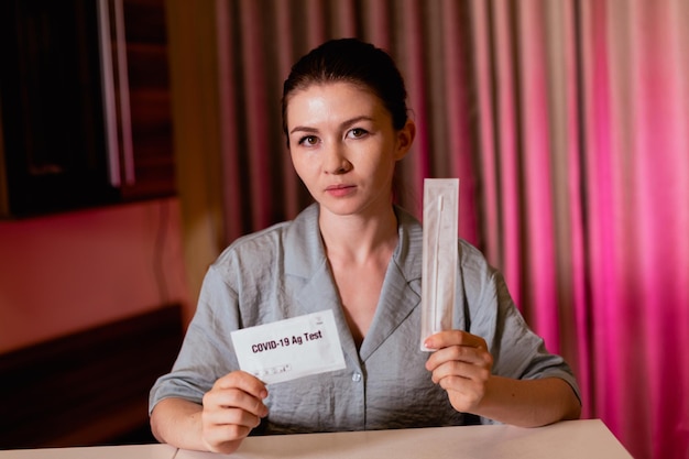 Primo piano di una donna che tiene in mano un pacchetto di test rapido COVID19