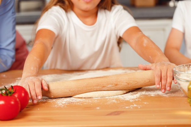 Primo piano di una donna con il suo bambino che impasta la pasta