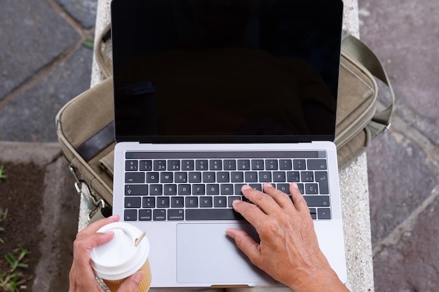 Primo piano di una donna d'affari che utilizza un computer portatile nel parco all'aperto Concetto di lavoratore nomade digitale