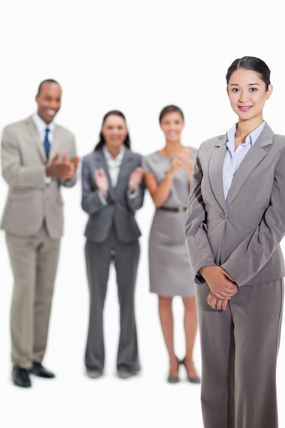 Primo piano di una donna d&#39;affari con i colleghi di lavoro che applaudono in background