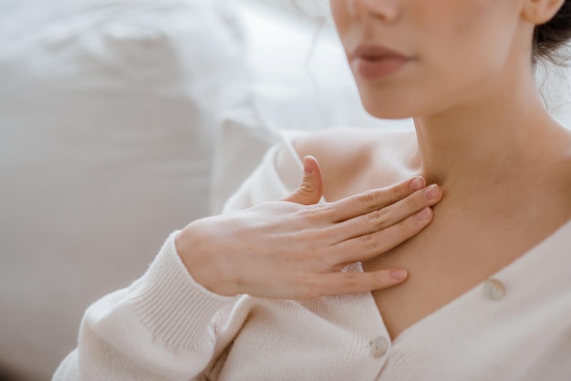 Primo piano di una donna felice in camice bianco che massaggia la pelle sana del viso dopo le procedure di bellezza