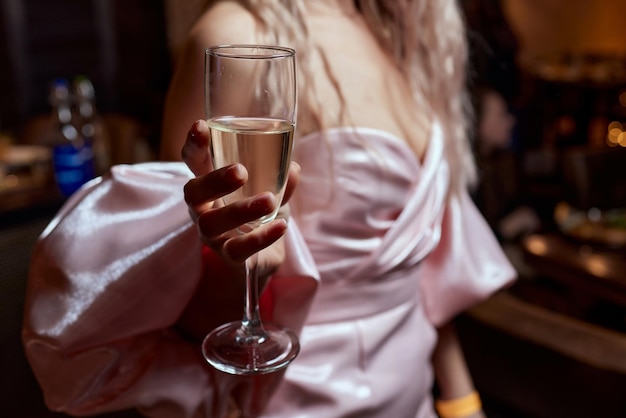 Primo piano di una donna splendida con un bicchiere di champagne party e celebrazione delle vacanze