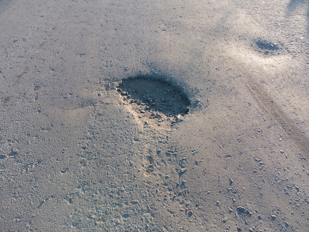 Primo piano di una fossa sull'argine Strada danneggiata