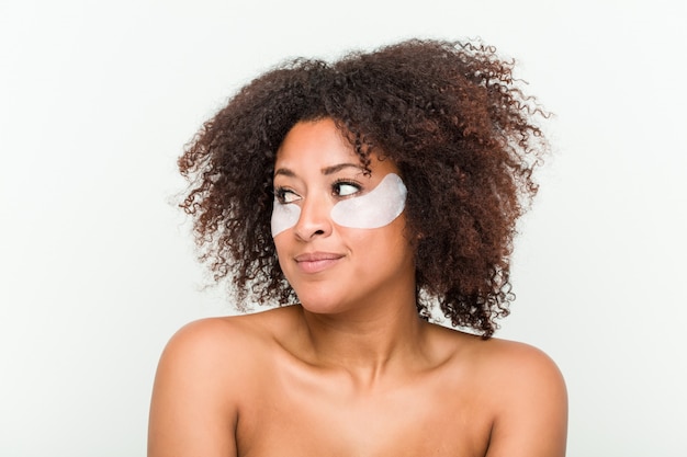 Primo piano di una giovane donna afro-americana con un trattamento della pelle degli occhi