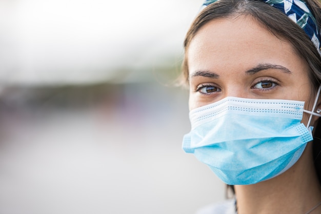 Primo piano di una giovane donna che indossa una maschera protettiva