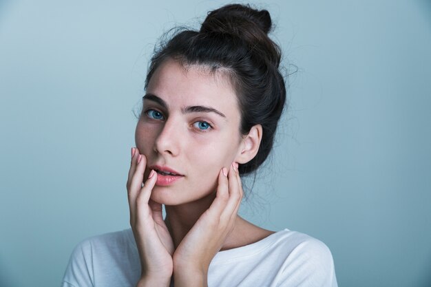 Primo piano di una giovane e bella ragazza casual isolata su sfondo blu