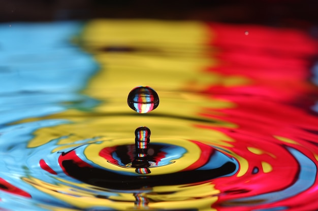 primo piano di una goccia d'acqua che cade e impatta con un corpo d'acqua