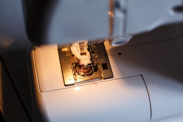 Primo piano di una macchina da cucire con luce accesa