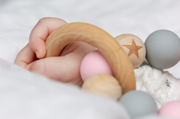 Primo piano di una mano del bambino, giocando con un giocattolo di legno.