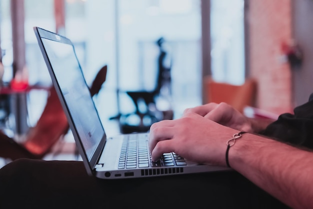 Primo piano di una mano dell'uomo che lavora sul fuoco selettivo del computer portatile