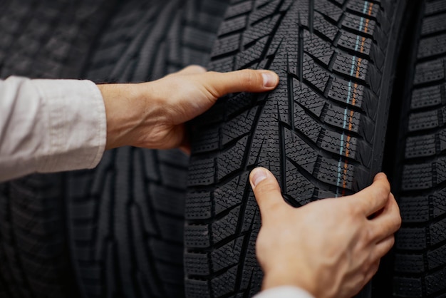 Primo piano di una mano di un uomo con pneumatici per auto