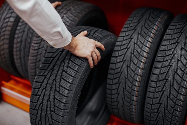 Primo piano di una mano di un uomo con pneumatici per auto