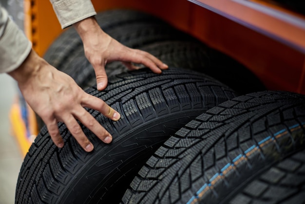 Primo piano di una mano di un uomo con pneumatici per auto