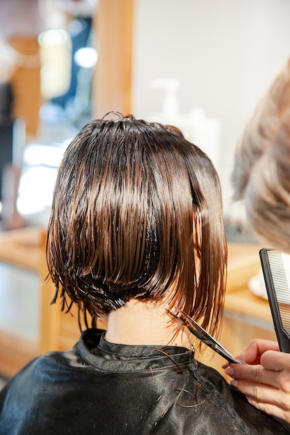 Primo piano di una mano maschile che taglia i capelli con le forbici