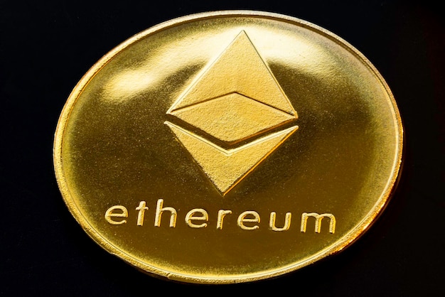 Primo piano di una moneta Ethereum d'oro con sfondo bianco Moneta di criptovaluta Mercato finanziario Macro Messa a fuoco selettiva