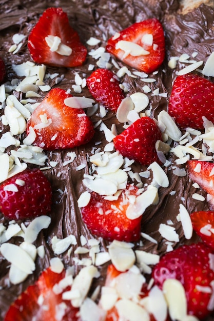 Primo piano di una pizza al cioccolato con fragole e mandorle