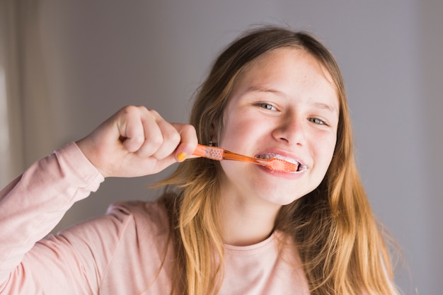 Primo piano di una ragazza che pulisce i denti con lo spazzolino da denti