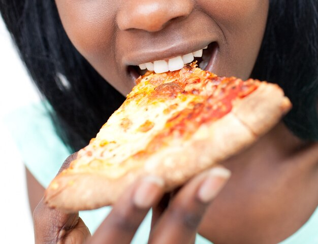 Primo piano di una ragazza teenager che mangia una pizza