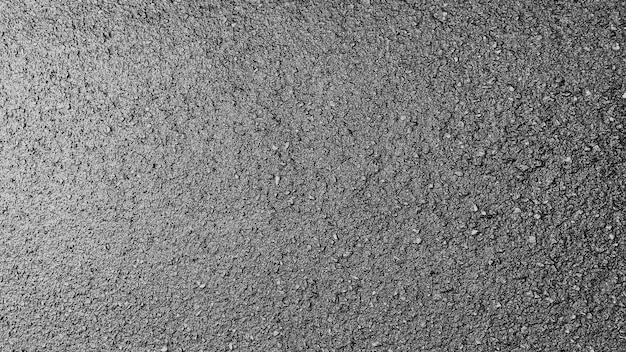 Primo piano di una trama di asfalto grigio con piccole pietre