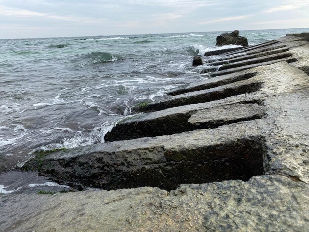 Primo piano di una vecchia grata di cemento nell'acqua in spiaggia