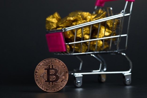 Primo piano di valuta digitale bitcoin e pepita d&#39;oro o minerale d&#39;oro nel carrello