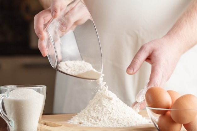 Primo piano di versare la farina per fare la pasta