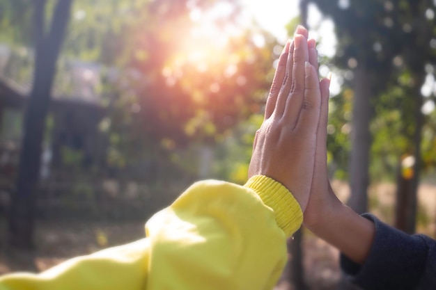 Primo piano due bambini che tengono insieme la mano sull'erba con luce solare Dopo il lavoro che fa successo